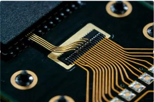 Microscopic image of a silicon chip connected to a substrate via gold wire bonding in the COB (Chip On Board) process