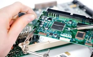 PCB soldering repair operation, using a soldering iron, solder wire and auxiliary clamp to fix the circuit board for solder joint repair