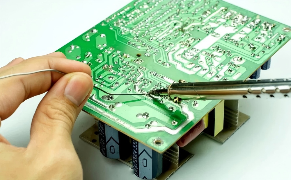 Backside solder joint repair of PCB, using a soldering iron and solder wire to reinforce and troubleshoot through-hole solder joints