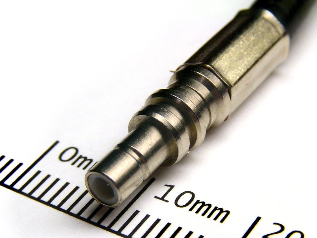 Close-up of an SMB RF connector, featuring a snap-on structure and compact size, for high-frequency RF cables