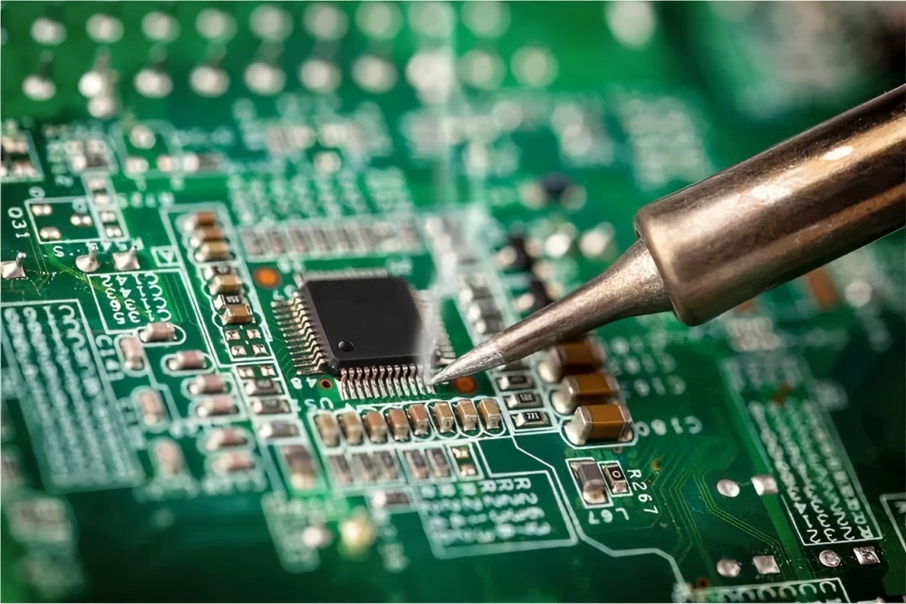 High-precision PCB soldering operation, soldering pins of a QFP package chip with a soldering iron