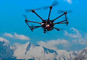 Flight shot of industrial multi-rotor drone with integrated antenna system, operating stably in snowy mountain environment, demonstrating the antenna's anti-interference and environmental adaptability
