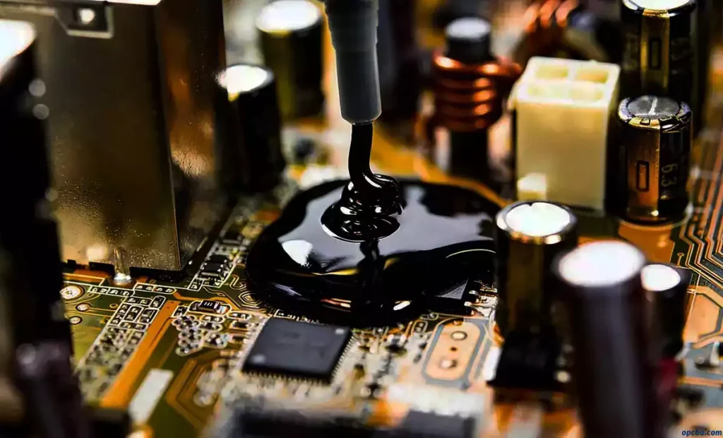 PCB potting process black potting compound being dispensed onto a printed circuit board, surrounded by electronic components like capacitors and inductors