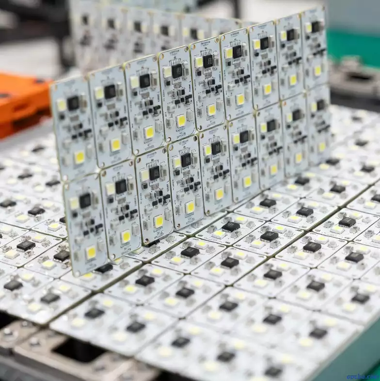 Rectangular LED PCB modules with driver ICs and yellow LEDs on a production line tray